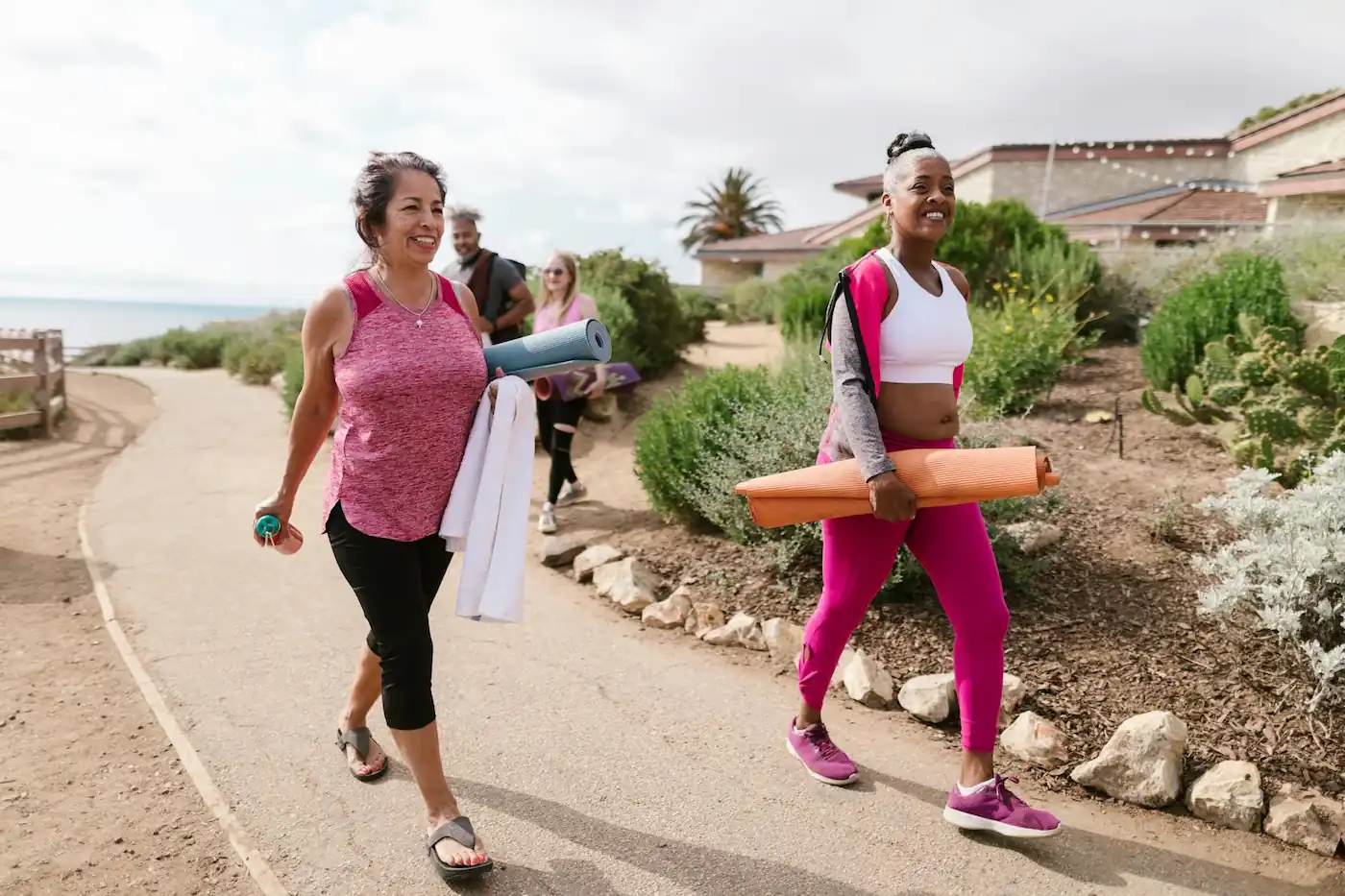 Women over 40 walking with yoga mats and hand weights—showcasing beginner strength and functional fitness outdoors.