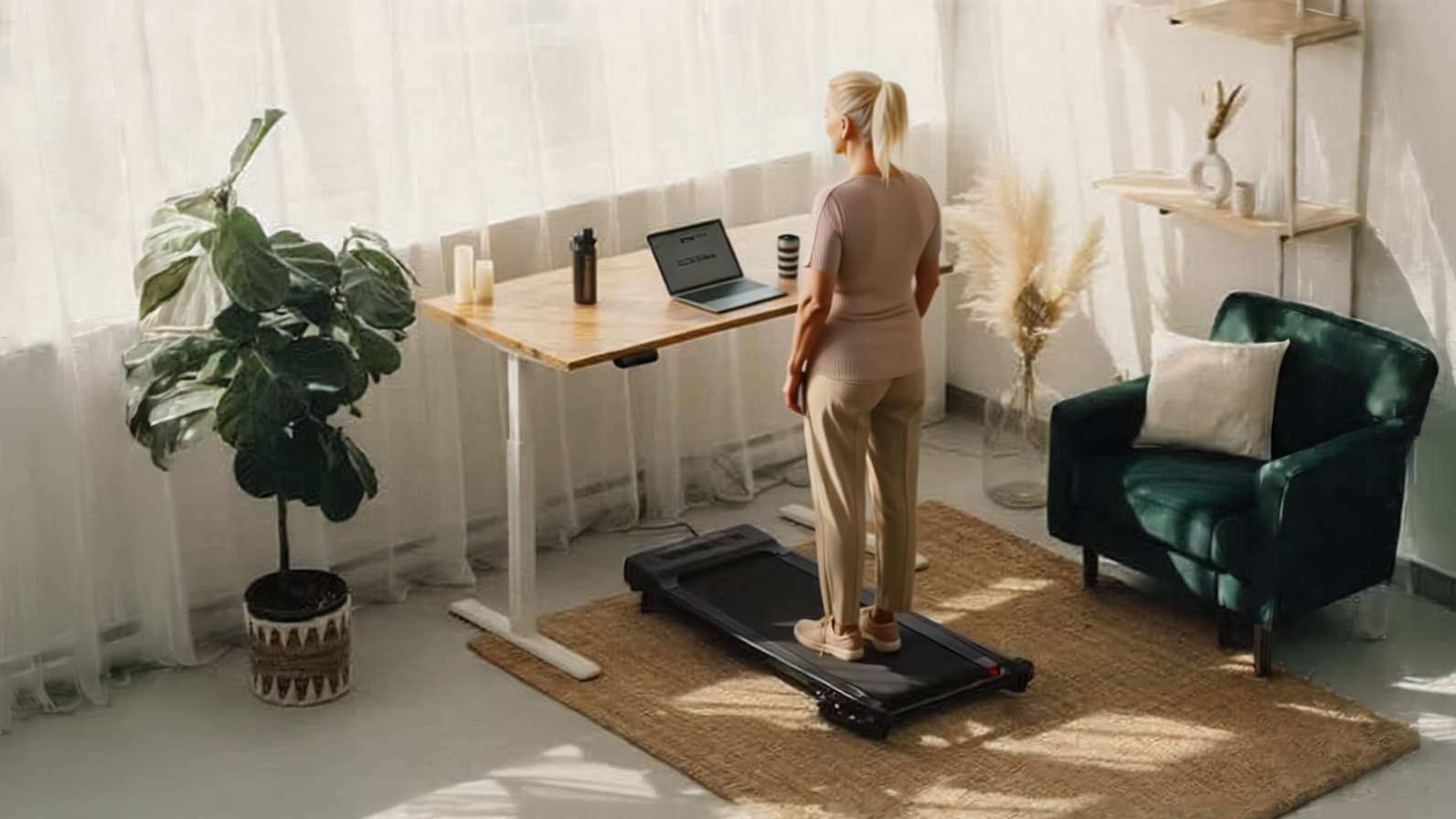 Woman walking on an underdesk treadmill while working at a standing desk
